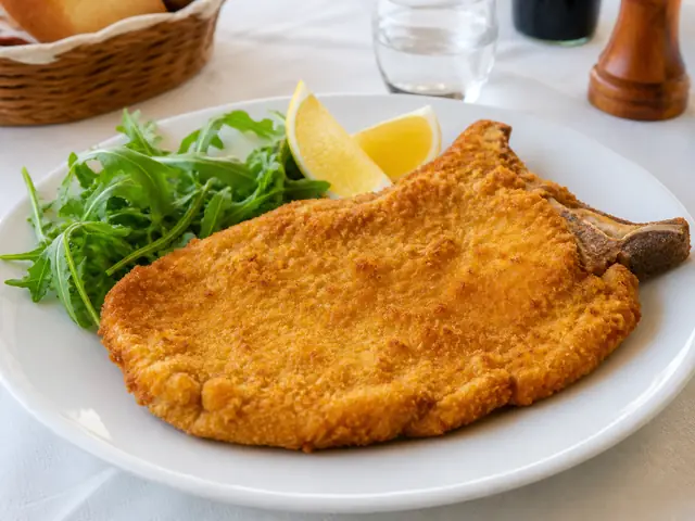 Finished Italian dish Cotoletta alla Milanese served for the recipe page.