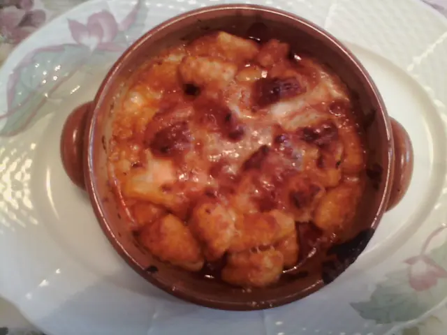 Finished plate of Gnocchi alla Sorrentina with pasta, sauce, and garnish.