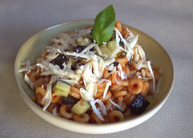 Finished plate of Pasta alla Norma with pasta, sauce, and garnish.