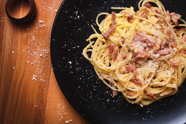Finished plate of Spaghetti Carbonara with pasta, sauce, and garnish.
