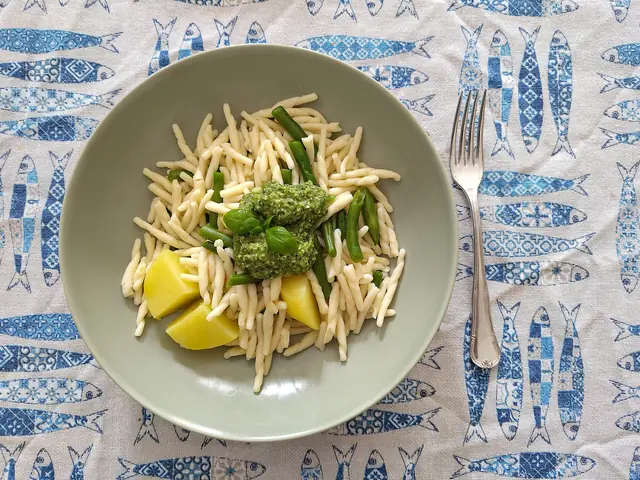 Finished plate of Trofie al Pesto with pasta, sauce, and garnish.